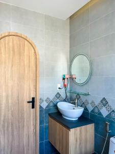 een badkamer met een wastafel en een spiegel bij Kat House Novaworld Phan Thiết in Bình Tú
