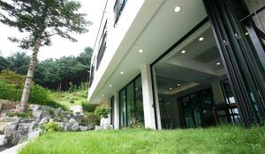 a building with glass doors and rocks in front of it at 91 Stay in Chuncheon