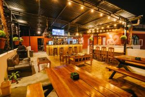 um restaurante com mesas de madeira e um bar em Dharma Backpackers em Pokhara