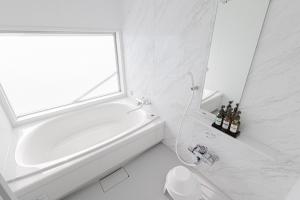 a white bathroom with a tub and a window at MARSOL C,S,Beach hotel - Vacation STAY 50798v in Chigasaki +3 photos