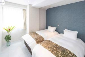 two beds in a hotel room with white sheets at MARSOL C,S,Beach hotel - Vacation STAY 50798v in Chigasaki