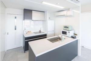 a white kitchen with a sink and a microwave at MARSOL C,S,Beach hotel - Vacation STAY 50798v in Chigasaki