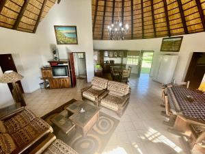 a living room with couches and a table and a tv at Nhambavale Lodge in Chidenguele