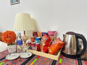 a table with a tray of food and a tea kettle at Huong Thao Hostel & Tours in Dien Bien Phu