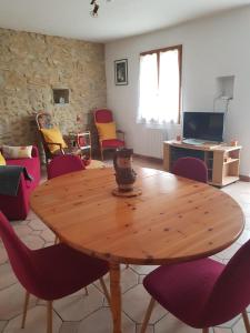 drewniany stół i krzesła w salonie w obiekcie Maison dans un village calme w mieście Carla-de-Roquefort