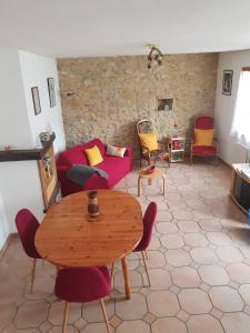 uma sala de estar com mesa e cadeiras em Maison dans un village calme em Carla-de-Roquefort