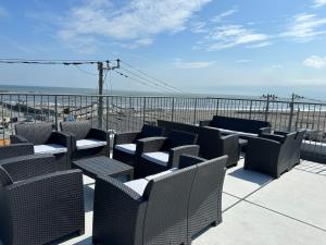 a row of chairs and tables on a balcony overlooking the ocean at MARSOL C,S,Beach hotel - Vacation STAY 51621v in Chigasaki