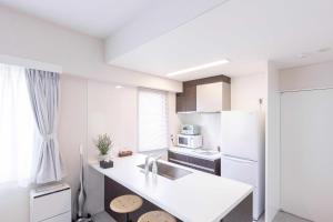 a white kitchen with a sink and a refrigerator at MARSOL C,S,Beach hotel - Vacation STAY 51621v in Chigasaki