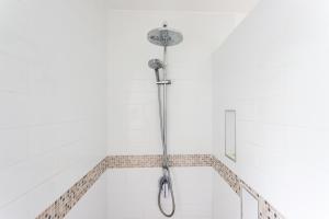 um chuveiro numa casa de banho com paredes brancas em Bella Beach Lodge em Rarotonga