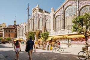 a group of people walking down a street in front of a building at Cool Central Market in Valencia