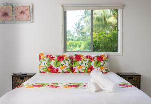 a bedroom with a bed with a window at Bella Beach Lodge in Rarotonga