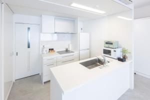 - une cuisine blanche avec évier et four micro-ondes dans l'établissement MARSOL C,S,Beach hotel - Vacation STAY 73619v, à Chigasaki