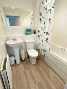 a white bathroom with a toilet and a sink at Central Retford 2 bed quiet apartment with parking in Retford