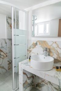 a white bathroom with a sink and a shower at Celia Residence in Athens