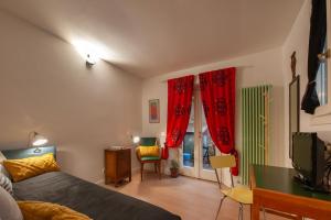 1 dormitorio con 1 cama y cortinas rojas en Le Casine - Tintori Apt, en Florencia