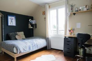 1 dormitorio con cama, escritorio y ventana en EXIGEHOME - Grande maison - 140m² - spacieuse et confortable, en Jouy-en-Josas