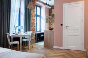 a bedroom with a bed and a table and a room with pink walls at 1555 Apartments V in Toruń +7 photos