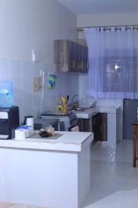 a large kitchen with white counters and appliances at 1BR Apartment, Canopy apartments Meru near KeMU university Main Campus in Meru