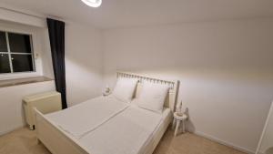 a bedroom with a bed with white sheets and a window at Ferienwohnung Forchtenberg in Forchtenberg