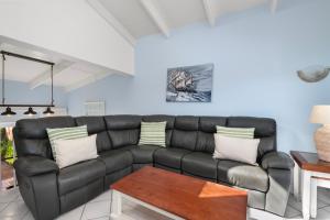a living room with a black leather couch at San Lameer Villa 2845 - 3 Bedroom Classic - 6 pax - San Lameer Rental Agency in Southbroom +28 photos