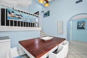a dining room with a wooden table and white chairs at San Lameer Villa 2845 - 3 Bedroom Classic - 6 pax - San Lameer Rental Agency in Southbroom