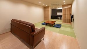 UTAKATA HOTEL HIMEJI في هيميجي: غرفة معيشة مع أريكة وطاولة