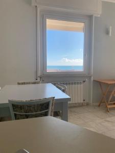 einen Tisch und Stühle in einem Zimmer mit Fenster in der Unterkunft La tua casa sul mare in Sestri Levante