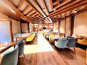 a restaurant with wooden ceilings and tables and chairs at Hotel Meerz , Srinagar in Srinagar