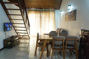 uma sala de jantar com uma mesa e cadeiras e uma escadaria em Lake infinity Penthouse em Nuwara Eliya