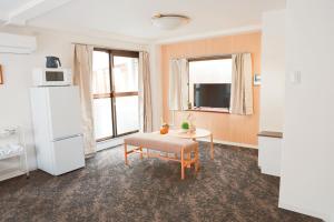 a living room with a table and a refrigerator at 龙猫民宿-梅田店303 in Osaka