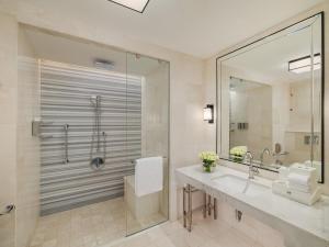 La salle de bains est pourvue d'une douche, d'un lavabo et d'un miroir. dans l'établissement Address Jabal Omar Makkah, à La Mecque