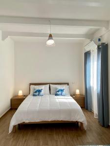 een slaapkamer met een groot wit bed met blauwe kussens bij Casa Esperanza in Procida