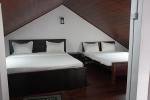 two beds in a room with a attic at Lake infinity Penthouse in Nuwara Eliya
