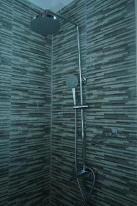 a shower in a bathroom with a stone wall at Lake infinity Penthouse in Nuwara Eliya +46 photos
