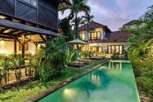 an exterior view of a villa with a swimming pool at Nativ Living Villa Legian 6BR Villa 16px Big Group Walk to 66 Beach in Seminyak
