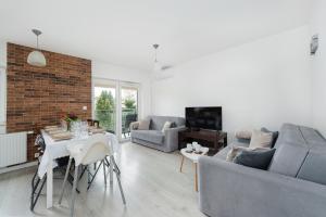 クラクフにあるBella Casa Premium Apartment - 104 Kobierzynskaのソファとテーブルのあるリビングルーム