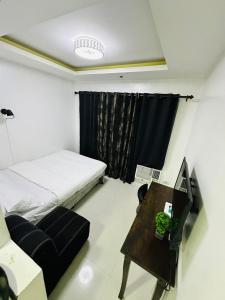 una camera con letto, tavolo e sedia di hotel in ermita manila birch tower a Manila