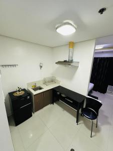 una cucina con scrivania e sedia in una stanza di hotel in ermita manila birch tower a Manila