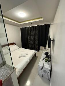 una piccola camera con letto e specchio di hotel in ermita manila birch tower a Manila