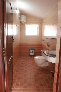 y baño con aseo y lavamanos. en Green Villa Ooty by Lexstays, en Ooty