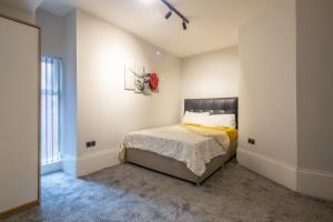 Un dormitorio con una cama en una habitación blanca. en MARSH lux 2, en Mánchester