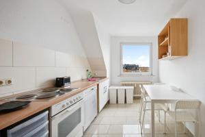 une cuisine blanche avec un comptoir et une table dans l'établissement Nice Apartment in Bremerhaven, à Bremerhaven