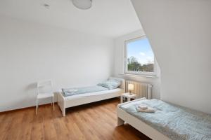 - une chambre avec 2 lits et une fenêtre dans l'établissement Nice Apartment in Bremerhaven, à Bremerhaven
