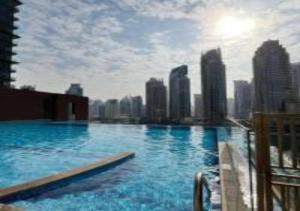 a swimming pool with a city skyline in the background at Key View - Marina Gate in Dubai