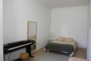 - une chambre avec un piano et un lit avec un miroir dans l'établissement Maison chaleureuse avec grande terrasse, à Nîmes