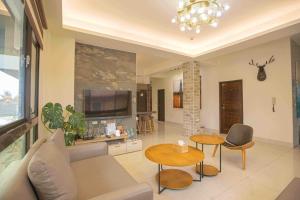 a living room with a couch and tables and a tv at 里舍民宿 in Jincheng