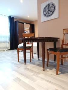 uma sala de jantar com uma mesa de madeira e cadeiras em Studio Standard em Zielona Góra