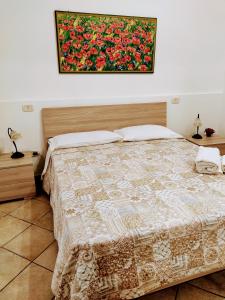 une chambre avec un lit avec un tableau sur le mur dans l'établissement Domo Janas GuestHouse, à Olbia