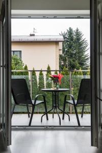 クラクフにあるBella Casa Premium Apartment - 104 Kobierzynskaのパティオ(テーブル、椅子2脚付)、バルコニー