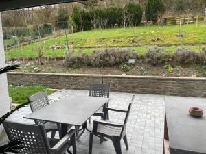 a patio with a table and chairs and a garden at Chambre privé 1 in Trier